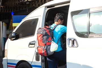 Backpack traveller travel using public van or mini bus in Thailand.