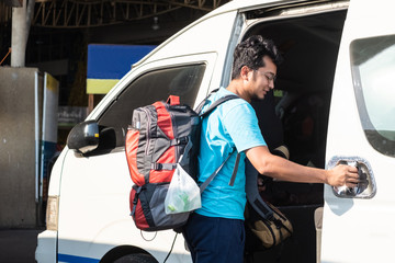 Backpack traveller travel using public van or mini bus in Thailand.