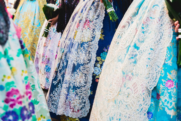 Valencia, Spain - March 17, 2019: Detail of the typical fallero dress, during the colorful and traditional parade of the offering, handmade embroidered dresses for the falleras.