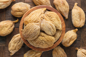 large dried figs in wooden bowl, top view.