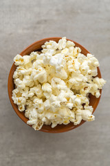 Ceramic bowl with popcorn on gray background