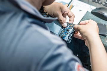 Close-up Of technician's hand showing process of repair and fix cell phone.