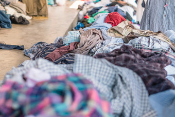 Stack of old many colors second hand cloth put on floor and foot path.