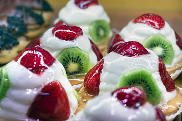 Closeup of greek shortcake - tartakia with cream, kiwis and strawberries