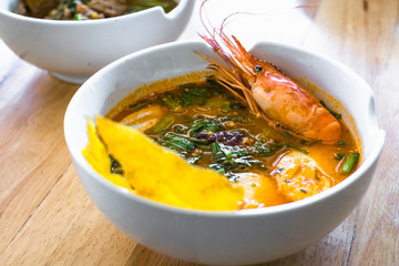 Thai spicy noodle shrimp soup with green vegetable and boiled egg.