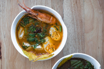 Thai spicy noodle shrimp soup with green vegetable and boiled egg. Top view.