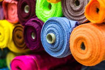 Colorful of many fabric rolls selling in market stall shop. Fashion desig concept.