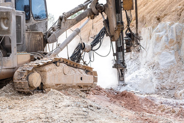 Rock driller on road comnstruction. Drilling rock in the works of creating a road.