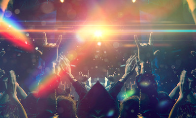 Concert spectators in front of a bright stage with live music