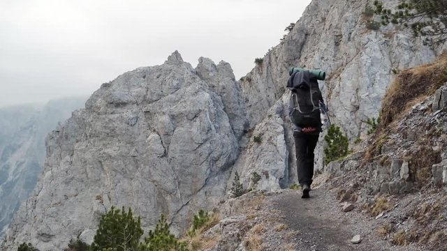Hiking from the famous Valbona to Theth valley. Valbone to Thethi in the Albanian Alps. Man backpacking and camping in the mountains.
