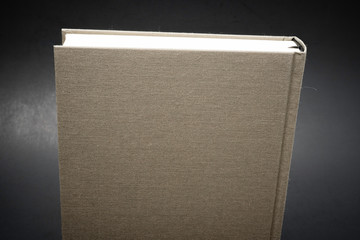 A close-up of the top portion of a grey-colored cloth-bound book with permanent black silk bookmark...