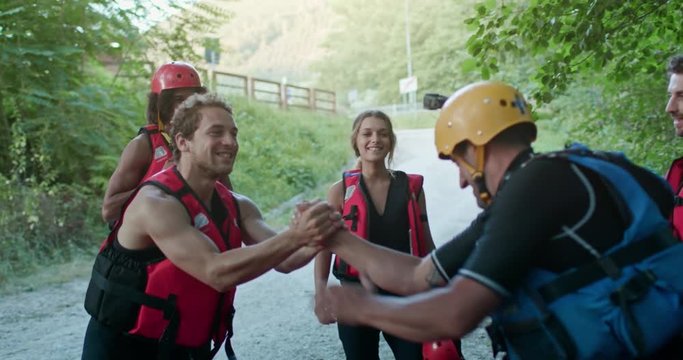 Group of happy people celebrating after rafting on river during sunset or sunrise. Warm back light. Friends italian trip in Umbria.4k slow motion