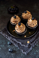 four cupcakes with blueberry and hazelnut