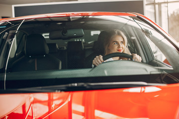 Woman buying the car. Lady in a car salon