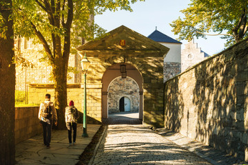 Beautiful sun ray in the evening and shading from tree to the entrance of Bergenhus fortress in Bergen, Norway - 272740388