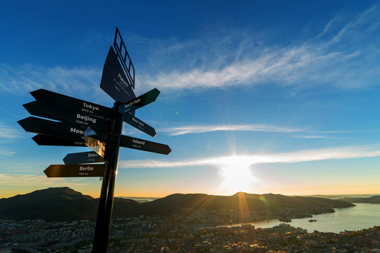 Beautiful blue sky and sunset with Signpost on Mount Floyen. The sign describe distance between here to the famous city in the world. Bergen, Norway