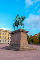 The equestrian statue of King Karl III Johan of Norway and Sweden stand in front of the Royal Palace with blue sky in morning summer. Oslo, Norway.  Text translation: The love of the people my reward. - 272740564