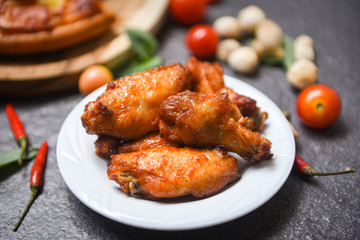 Baked chicken wing bbq grill on plate - hot and spicy chicken and sauce on dark background