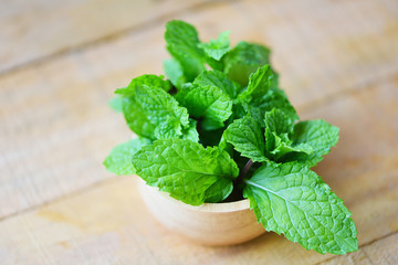 peppermint leaf in a wood bowl - Fresh mint leaves on the wooden background