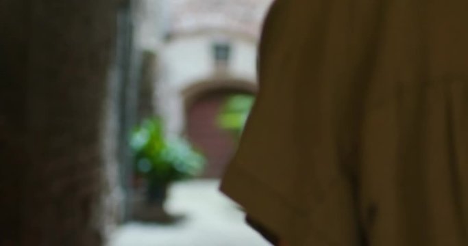 happy similing tourist woman walking and looking around amazed through small street visiting rural town of Spello.Back follow.Friends italian vacation trip in Umbria.4k slow motion