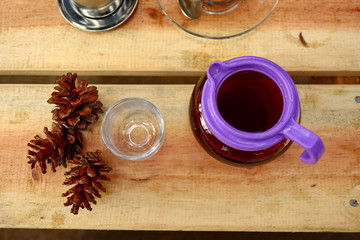 coffee drinks served on wooden tables with small glasses, with added pine decorations