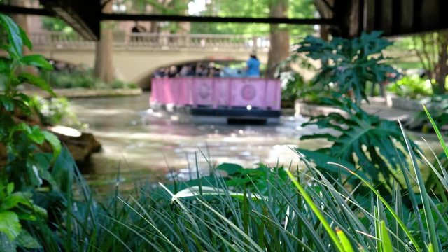 San Antonio River Walk with blurred tourists in boats 