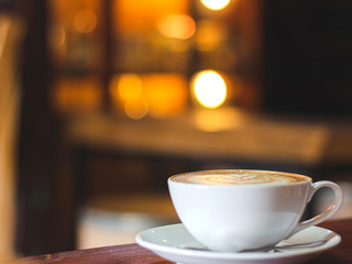 Cup of coffee on wooden table in the coffee shop.