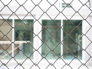 Fototapeta premium Protected house behind fence,Close up of a wire fence with a blurred 