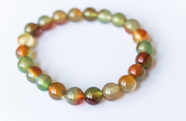 supplement a good fortune and opulence by Thee colorful jade bracelet amulet, bracelet made of natural stones on a white background