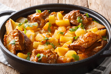 Delicious stew of short beef ribs with potatoes with gravy close-up in a pot. horizontal
