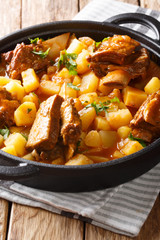 Beef ribs stewed with potatoes and gravy close-up in a pot. vertical