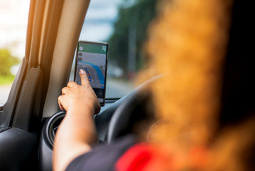 Woman using gps navigation in cellphone while driving car,Woman searching destination direction or address on gps or navigator application ,GPS mobile phone and transportation concept ,