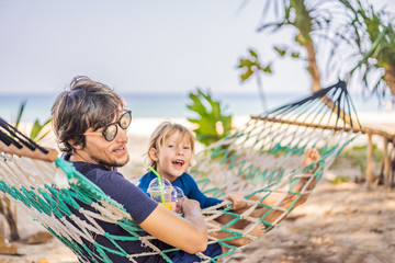 Dad and son having fun in a hammock with a drinks