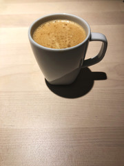 top view of Black coffee in white cup on the wooden table with cafe light. Copy space