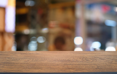 Empty dark wooden table in front of abstract blurred bokeh background of restaurant . can be used for display or montage your products.Mock up for space.
