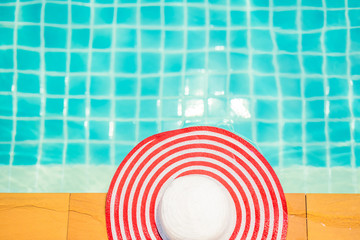 Hat at the side of swimming pool, summer travel concept