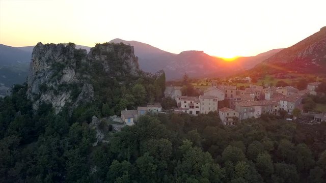 The last sunrays peeking through the mountain tops at the French village Rougon