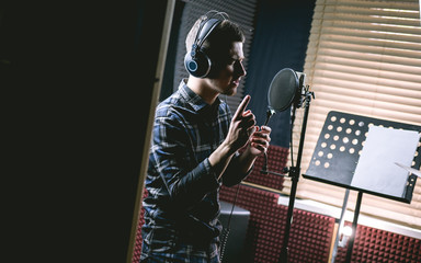 The young guy singing in recording studio