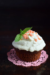 Fototapeta na wymiar Chocolate cupcake with vanilla cream and mint leaf. Happy Birthday. Dark photo