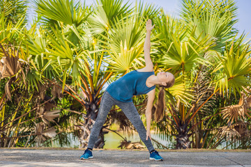 Woman doing yoga in a tropical park