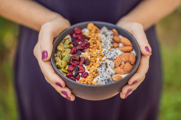 Women's hands are preparing a smoothie bowl