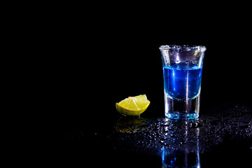 Blue vodka in glass and lemon with salt.
