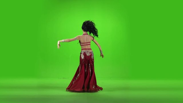 Beautiful belly dancer dancing ethnic dances against green screen.