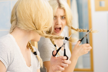 Woman cutting blond braid hair