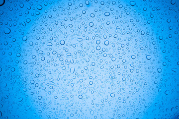 Rain droplets on blue glass background, Water drops on glass.