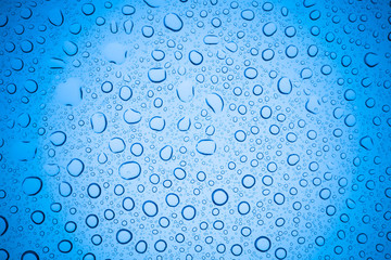 Rain droplets on blue glass background, Water drops on glass.