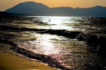 suggestive image of a beach in Sicily with promontory in the background