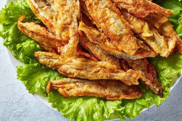 Fried small capelins on a white plate