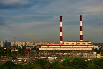 Fototapeta na wymiar power plant with pipes on evening sky background