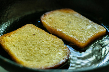 top view of frying bread toasts in the pan, the process of cooking fast snack, breakfast or lunchs